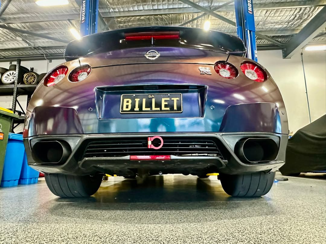 Rear view of the workshop's wide tyre R35 GT-R roll racing car with BILLET plates inside the workshop